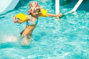 Cute toddler girl playing in swimming pool photo