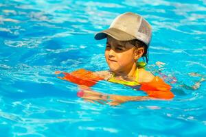 Cute toddler girl playing in swimming pool photo