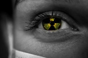 un símbolo de radiación en el ojo de un joven mujer. de cerca de un mujer en un mascarilla. foto