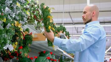 Guy buy Christmas wreath in supermarket. video