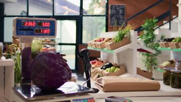 Electronic scale in eco friendly store next to organic locally grown produce. Modern weighing machine used in local neighborhood shop for bulk products and fruits or vegetables. video