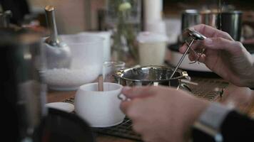 a girl stirring wax in a metal ladle, making candles video