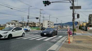 nara, japan på oktober 5, 2023. trafik i främre av porsche Centrum nara och suzakumon Port heijo palats webbplats historisk parkera. ganska upptagen med bilar, buss, lastbilar, tung fordon och behållare lastbilar. video