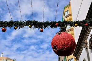 a red ball hanging from a string with christmas decorations photo