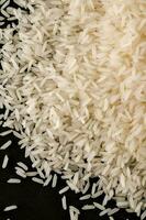 un pila de blanco arroz en un negro superficie foto