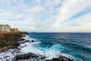 ocean waves hit and crash against stones photo