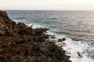 ocean waves hit and crash against stones photo