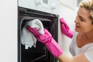 joven mujer haciendo tareas del hogar, limpieza el cocina foto