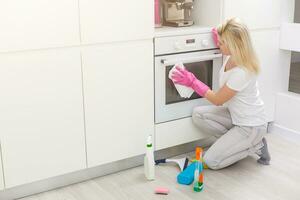 joven mujer haciendo tareas del hogar, limpieza el cocina foto