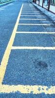 Empty parking space for motorbikes and bicycles with yellow lines. Automobile parking garage at office area parking lot photo