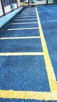 Empty parking space for motorbikes and bicycles with yellow lines. Automobile parking garage at office area parking lot photo