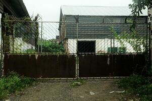 The fence of an empty house is damaged and not maintained photo