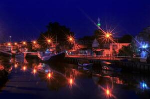 Upstream of the river at Pasuruan Harbor in Indonesia, many fishing boats dock at night photo