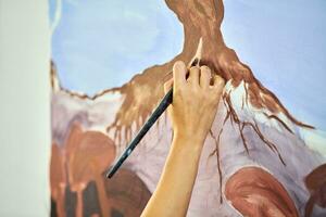 niña artista mano sostiene pintar cepillo y sorteos resumen surrealista paisaje en lona foto