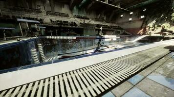 An abandoned swimming pool in a large building, void of water and life video