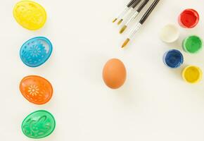 Preparing an Easter egg for painting. Paints. stencils and brushes on a white background. Place for text. photo