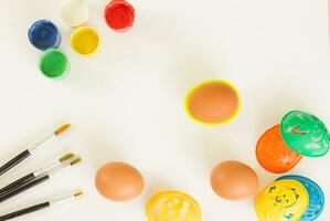 Stencils for painting Easter eggs, paints and brushes on a white background. Preparing for Easter. Copy space. photo