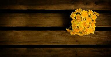 Bouquet of dandelions on a wooden background, top view photo