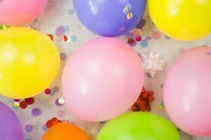 Festive background. Multicolored balloons, confetti on a gray background. Preparing for the celebration. photo