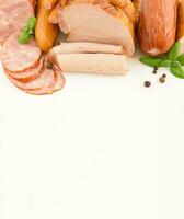 Different types of sliced sausages and ham isolated on a white background. Copy space photo