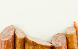 Different types of sliced sausages and ham isolated on a white background. Copy space photo