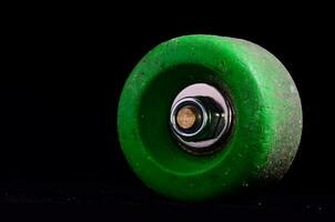 a green wheel with a metal center on a black background photo