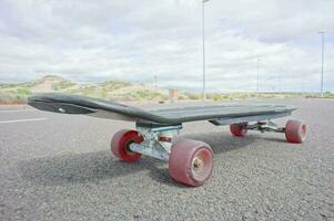 a skateboard with red wheels sitting on the ground photo