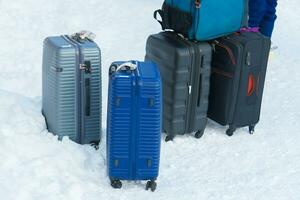equipaje maleta con nieve, turista arrastrando equipaje durante caminando en Nevado pasarela invierno viajar, viaje y vacaciones concepto foto