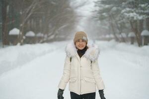 happy Traveler with Sweater and backpack walking on snow covered forest in frosty weather. Winter Travel, Adventure, Exploring and Vacation concept photo