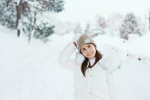 happy Traveler with Sweater and backpack walking on snow covered forest in frosty weather. Winter Travel, Adventure, Exploring and Vacation concept photo