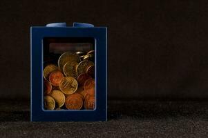 un pequeño azul caja con monedas dentro foto