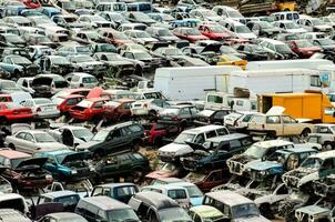 a large pile of cars in a scrap yard photo