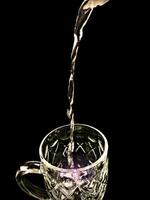 Aesthetic photo of pouring water into a glass with black background