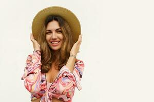 Beautiful european woman in stylish summer outfit and straw hat posing on white background. Fashion look. photo