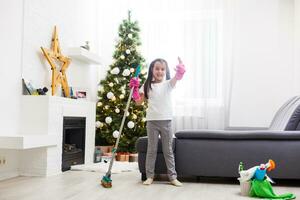 little girl cleaning after christmas on the background of Christmas lights. photo