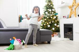 little girl cleaning after christmas on the background of Christmas lights. photo