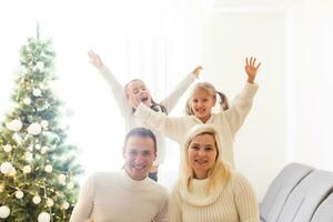 contento familia padre madre y niños sentado por hogar en Navidad víspera foto