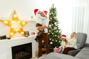 Happy family playing with Christmas gifts at home photo