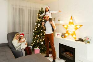 happy family father mother and children sitting by fireplace on Christmas Eve photo