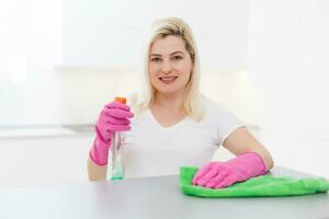 Woman cleaning dust from bookshelf. Young girl sweeping shelf, spring cleaning concept, copy space photo