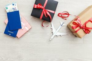 Christmas airplane travel concept. Passports, toy white plane. Gift box photo