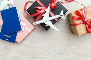 Christmas airplane travel concept. Passports, toy white plane. Gift box photo