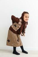 Portrait of little funny girl dressed like an old witch posing with broom in front of White background photo