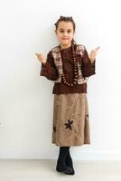 Portrait of little funny girl dressed like an old witch posing with broom in front of White background photo