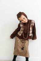 Portrait of little funny girl dressed like an old witch posing with broom in front of White background photo