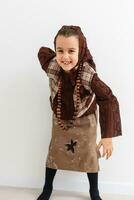 Portrait of little funny girl dressed like an old witch posing with broom in front of White background photo