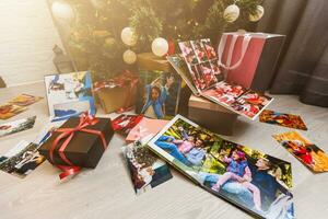 New Year celebrating. Photobook with photos of summer travel under the Christmas tree