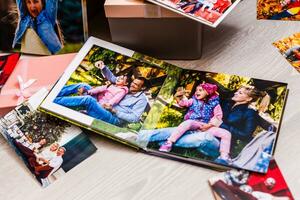 New Year celebrating. Photobook with photos of summer travel under the Christmas tree