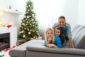 Young family on Christmas morning exchanging presents and enjoying their time together. photo