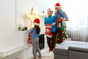 familia, Navidad, Navidad, invierno, felicidad y personas concepto - sonriente familia en Papa Noel ayudante sombreros con muchos regalo cajas y Bengala luces foto